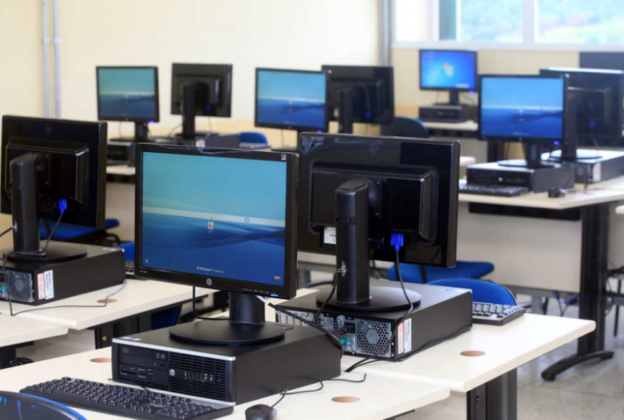 Salón de class con computadoras de escritorio.